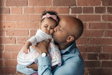 father gives baby daughter a kiss