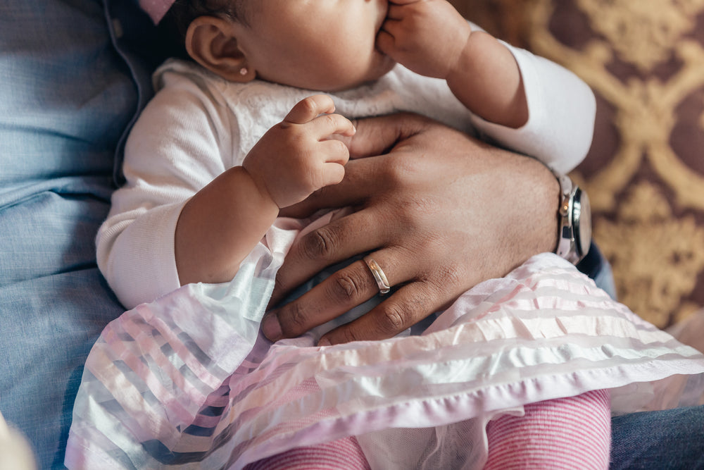 father holding baby daughter in lap