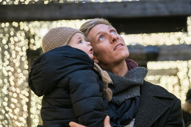 father holding child looking up