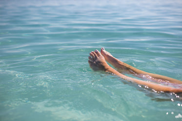 feet floating in blue water
