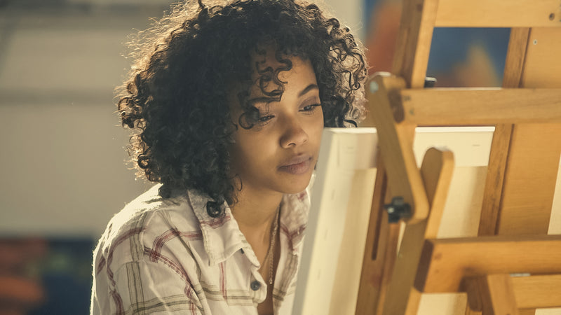 A close portrait of an artist at work in her studio