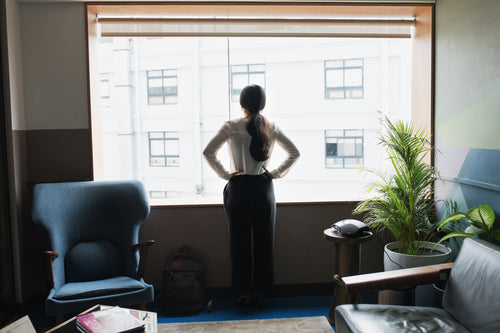 female executive looks out modern office window