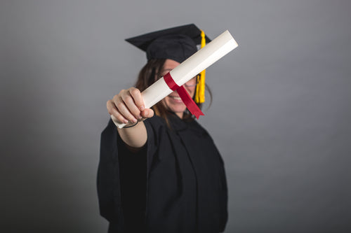 female grad student holding out diploma