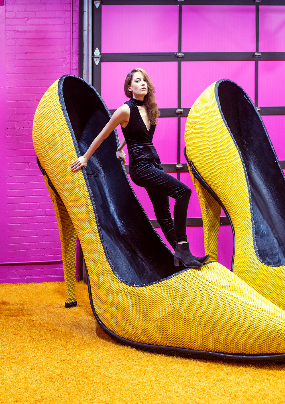 female model balances inside a giant yellow shoe