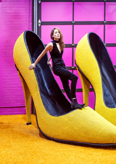 female model balances inside a giant yellow shoe