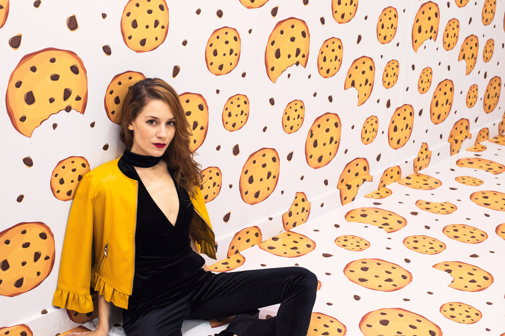 female model leaning against wall of cookie-themed room