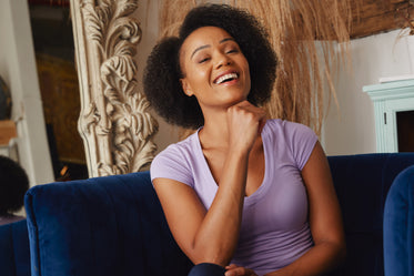 female model smiles in blue chair