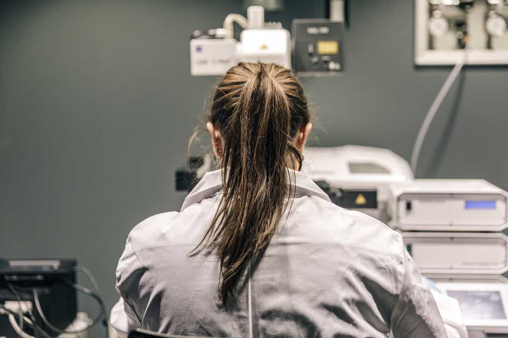 female scientist looking through microscope