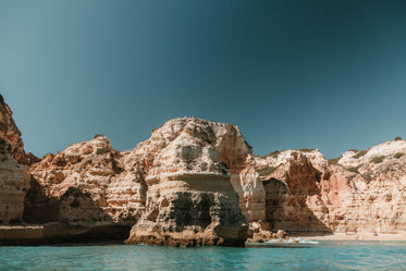 figures line rocky outcrops protruding into the sea