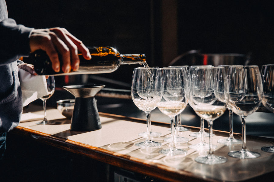 Tall glasses being filled on a kitchen counter