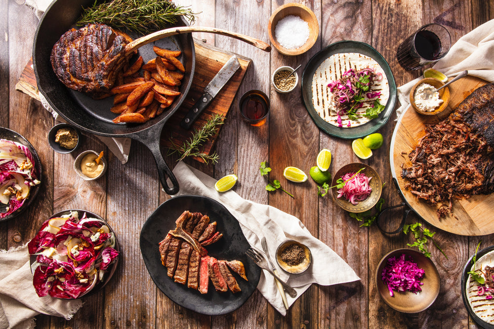 flatlay iron skillet with meat and other food