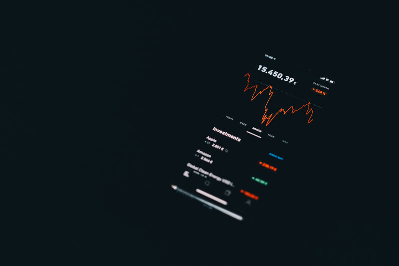 a screenshote of a stock market trading system - flatlay of a black phone showing graphs on the scre