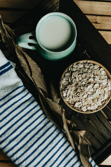 flatlay of a bowl of oats tea and a towel