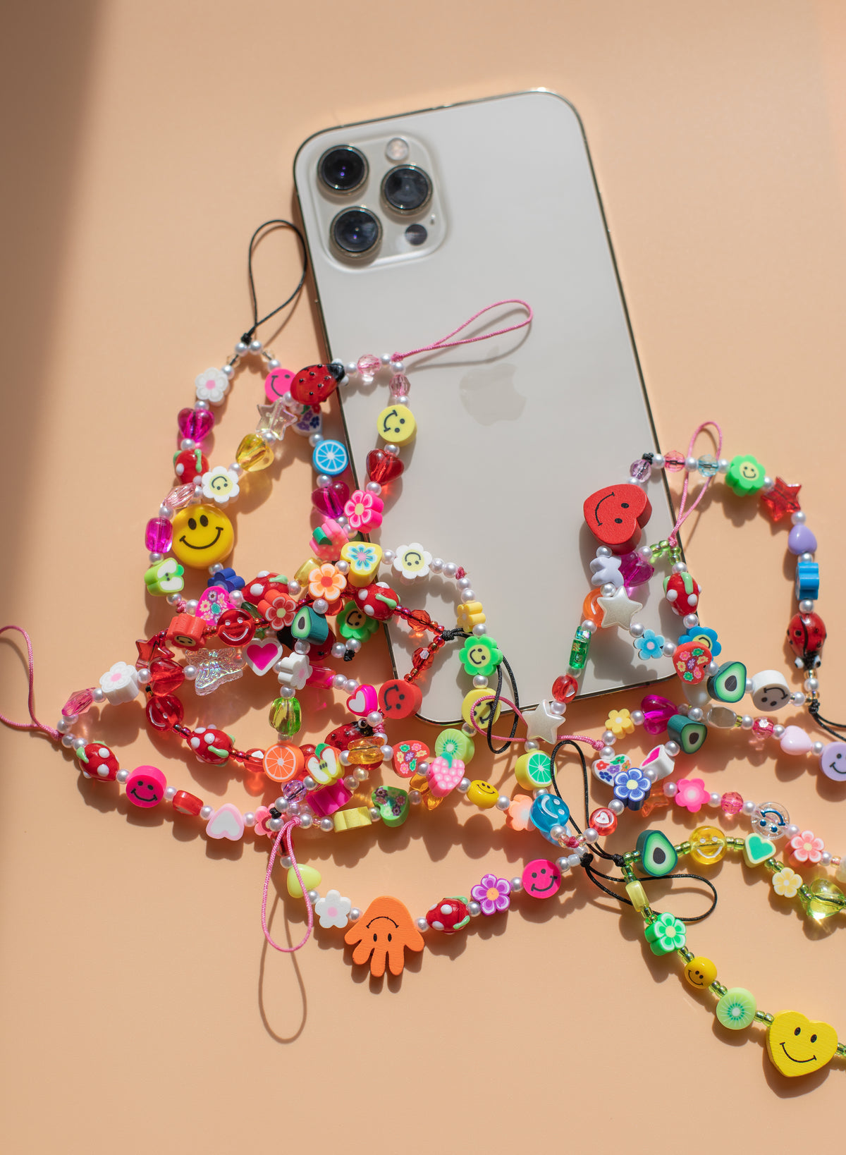 flatlay of a cell phone and colourful beaded string