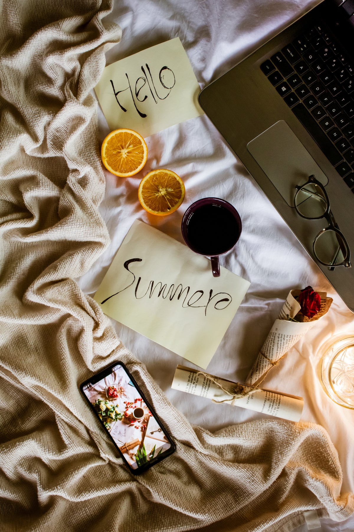 flatlay of a cozy bed with the words hello summer