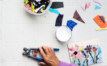 flatlay of a grey table with a mosaic and tools