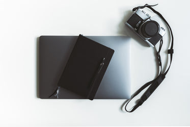 flatlay of a laptop and camera with stationary