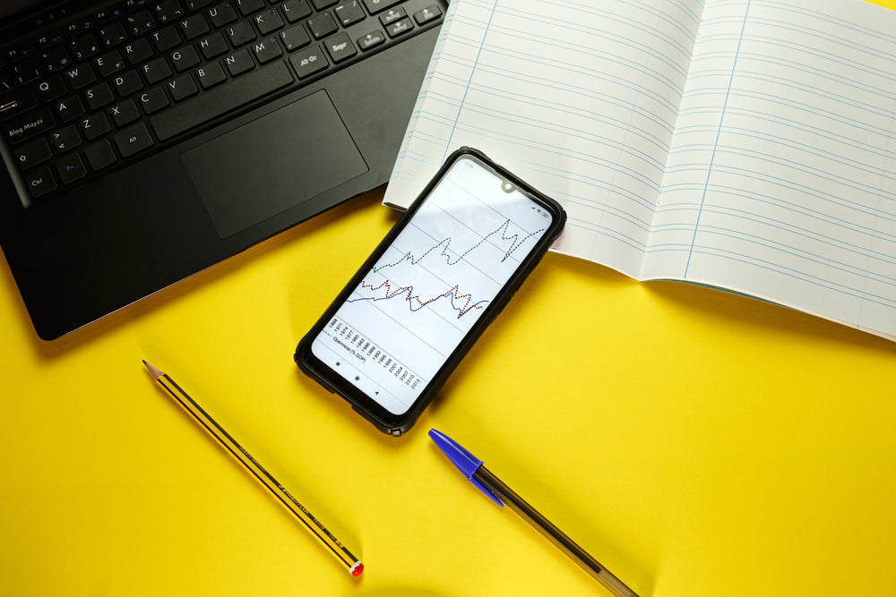 flatlay of a laptop and cellphone with notebook