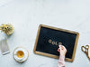 flatlay of a model spelling "gold" on a blackboard