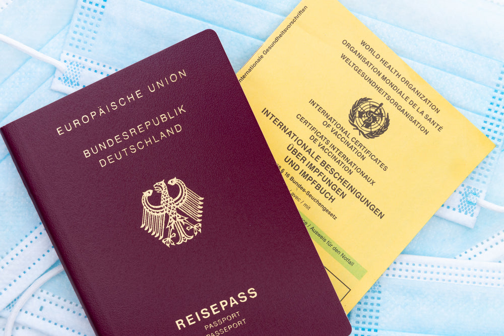 flatlay of a passport vaccine card and facemasks