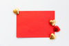 flatlay of a red envelope with gold and red chocolates