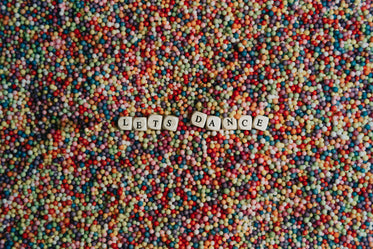 flatlay of blocks spelling lets dance on colorful dots