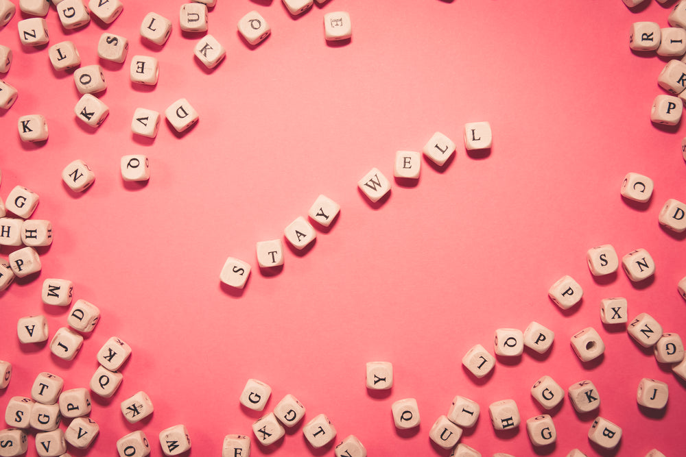 flatlay of blocks the middle spelling out stay well