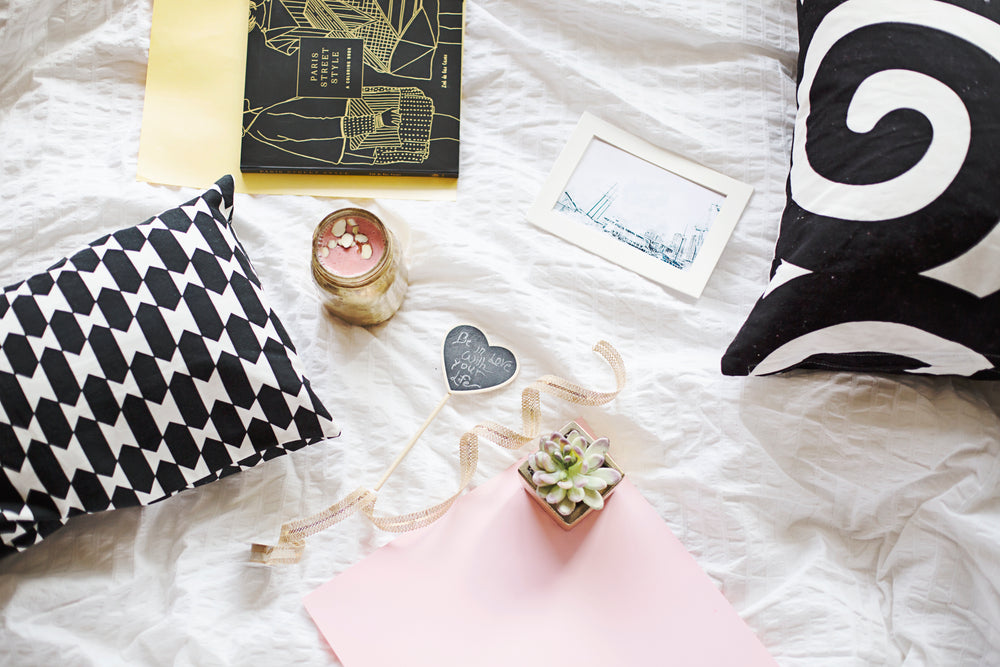 flatlay of books with plants and a smoothie on a white sheet