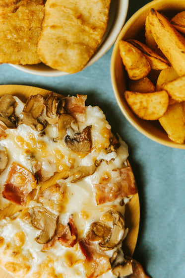 flatlay of cheese mushroom and bacon pizza