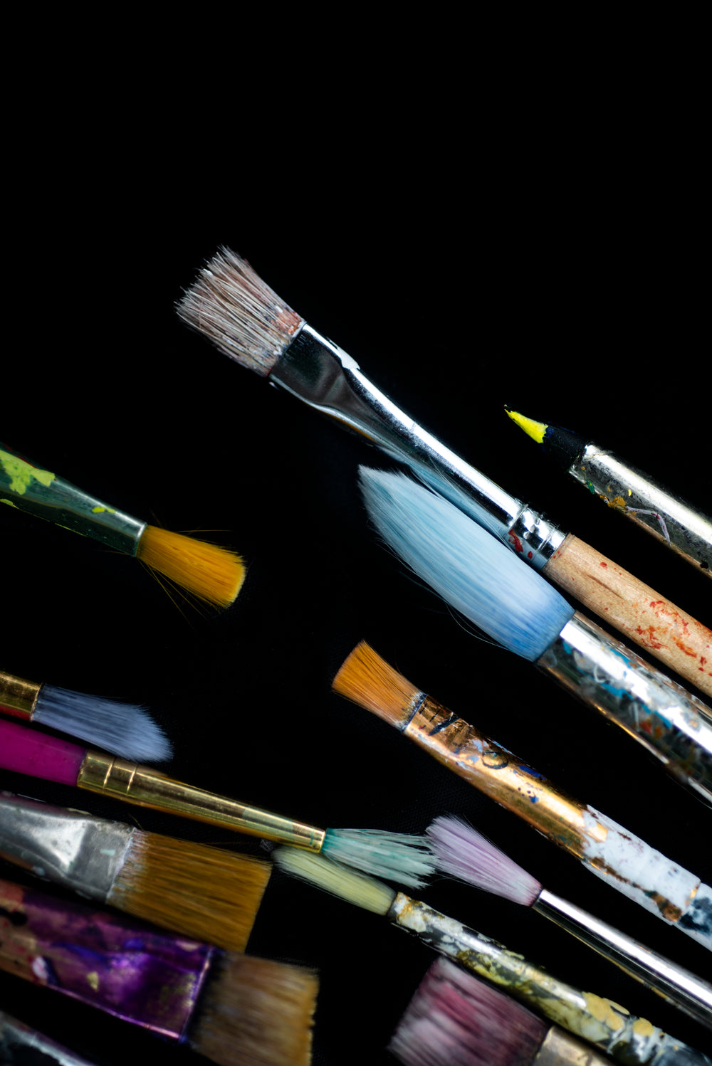 flatlay of clean paint brushes on a black surface