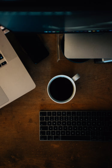 flatlay of coffee and computer on wooden surface