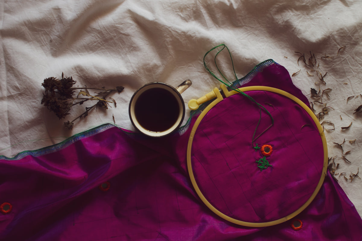 flatlay of embroidery coffee and dried flowers