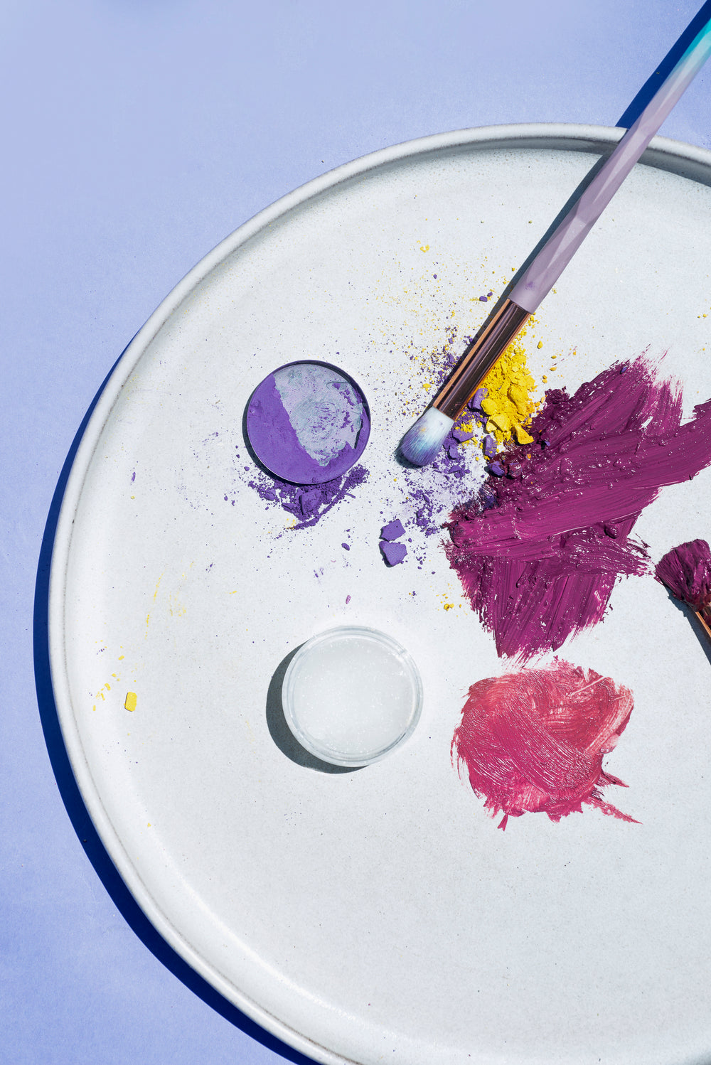 flatlay of makeup on a round white plate