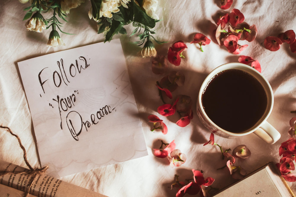 flatlay saying follow your dreams with coffee next to it