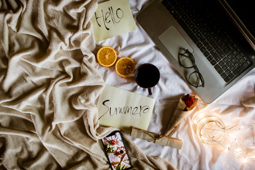 flatlay welcoming summer with a laptop and cellphone