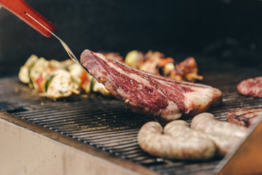 flipping a big ribeye steak on bbq