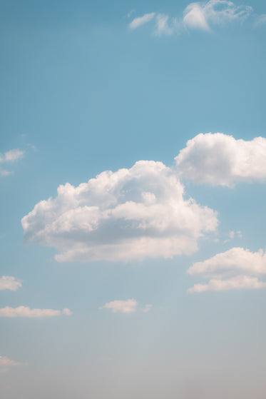 fluffy clouds in a light blue sky on a clear summer day