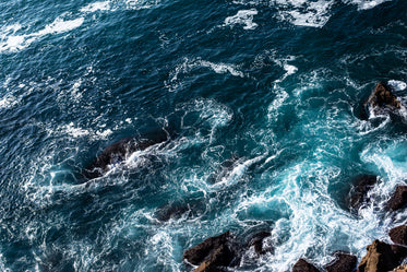 foaming blue water rolls over rocks