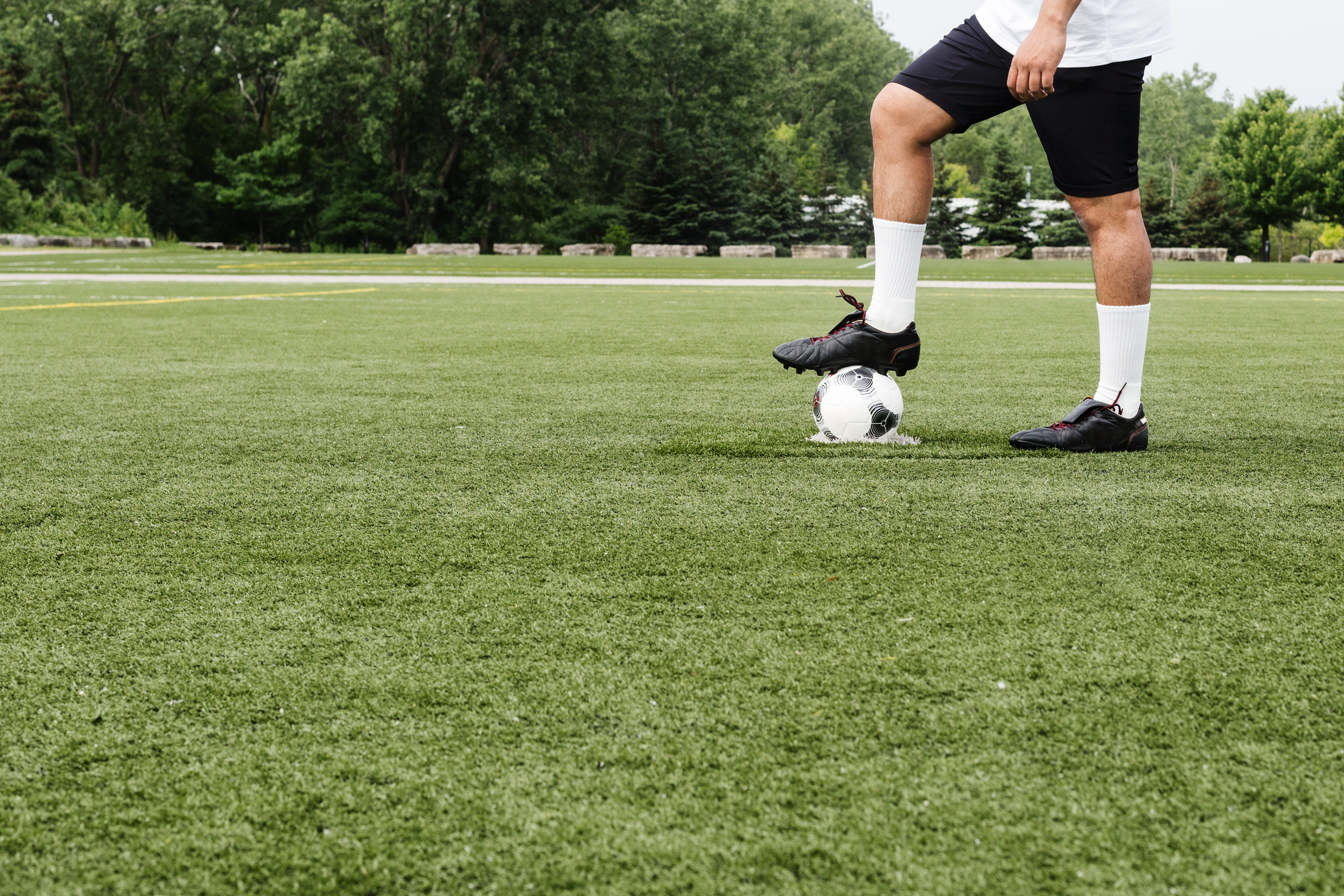 Sapatos de jogador de futebol de bola de futebol e pé no campo