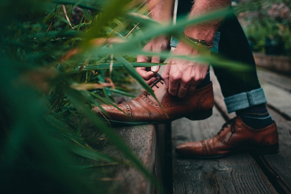 footwear close up man tying shoelace from side