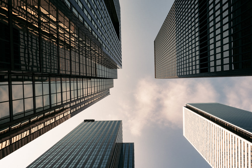 four buildings from below small clouds