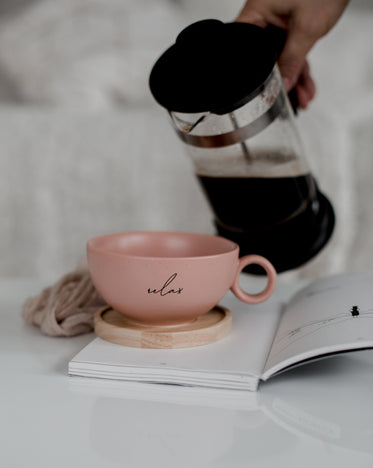 french press black coffee and a pink cup