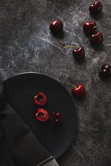fresh cherries scattered on dark background