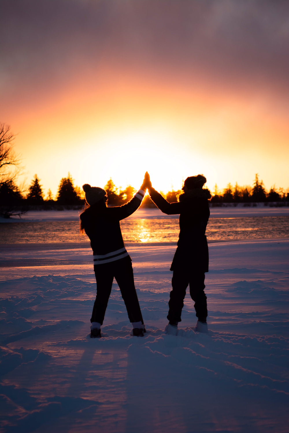 friends high-five on semi-frozen lake