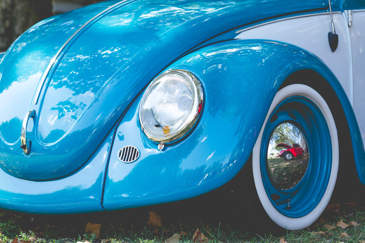 front of a bright blue classic car with round hood