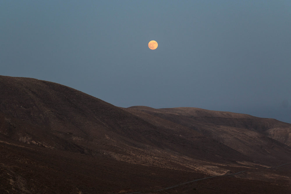 full harvest moon over spanish hillside