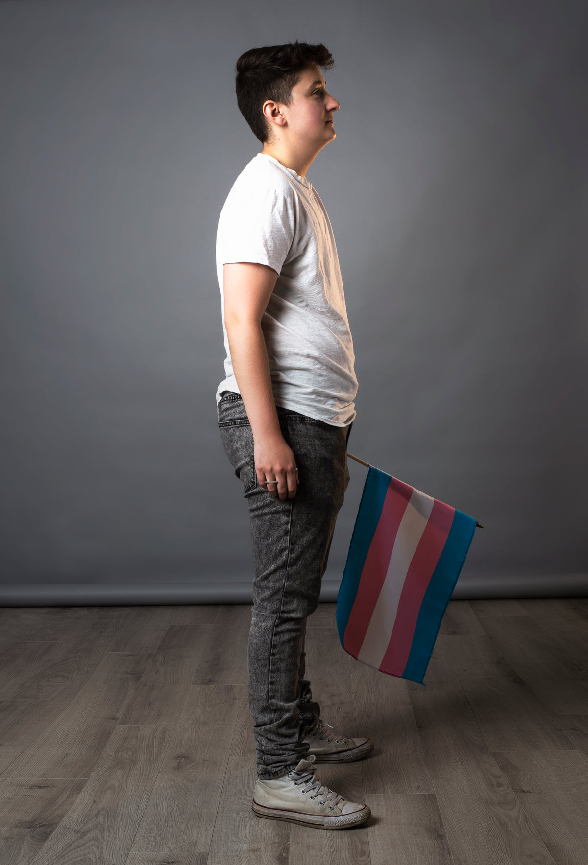 full side view of person holding trans pride flag