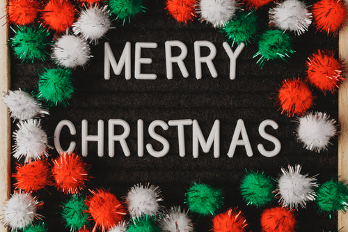 fuzzy decorations surround the words merry christmas