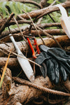gardening tools leaning against a pile of wooden sticks