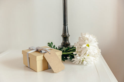 gift with flowers on bedside table